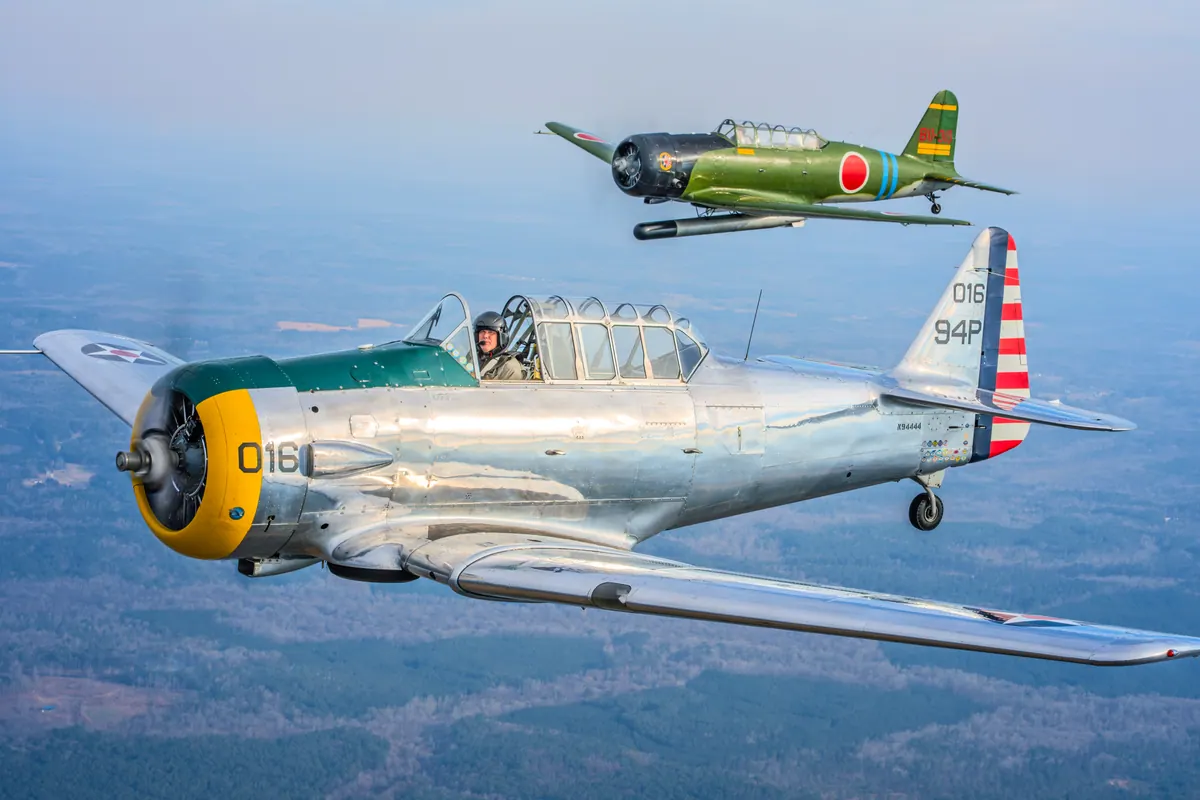 The polished silver trainer '016' heads left with the green 'Kate' torpedo-bomber replica following just above