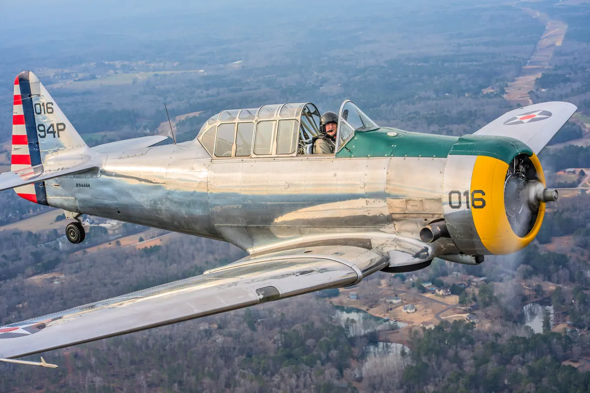 Close view of the polished silver trainer '016' banking slightly over wooded hills